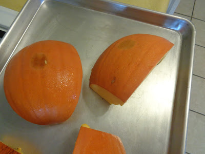 The pumpkin quarters are lightly sprayed with cooking spray and put into the oven flesh side down. 
