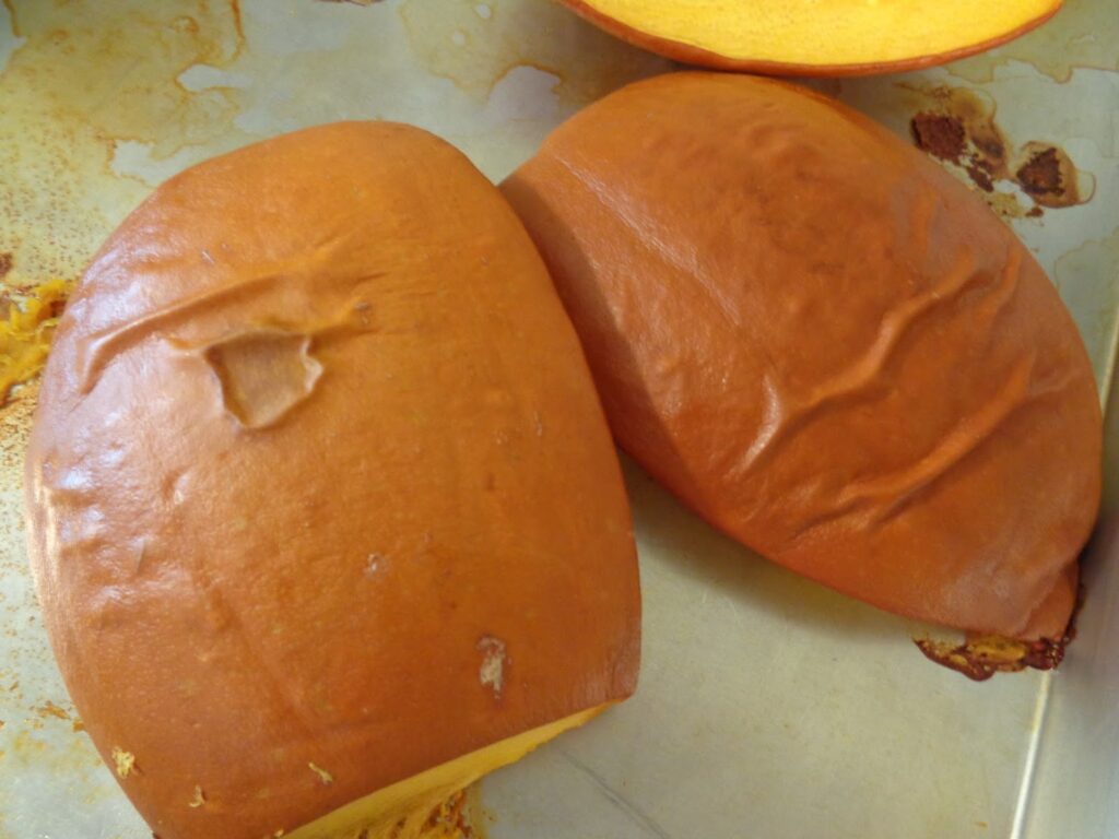 The skins of the roasted pumpkin are creased and wrinkled and ready to peel away easily. 