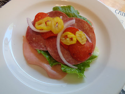 The Italian Grinder roll ups are ready to be rolled. Thinly sliced honey ham, salami and lettuce are topped with pepperoni, sliced pepperoncini peppers and red onions.