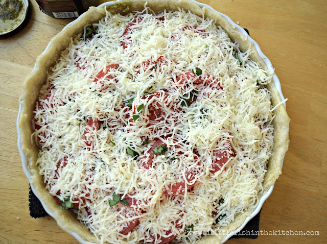 A generous layer of cheese finishes off a flavorful Southern tomato tart with pesto.