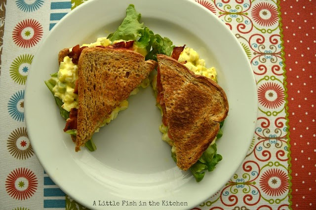 Layers of crisp lettuce, creamy egg salad, crisp bacon and flavorful ripe tomatoes are sandwiched between toasted slices of white bread. The oozing egg salad looks inviting!