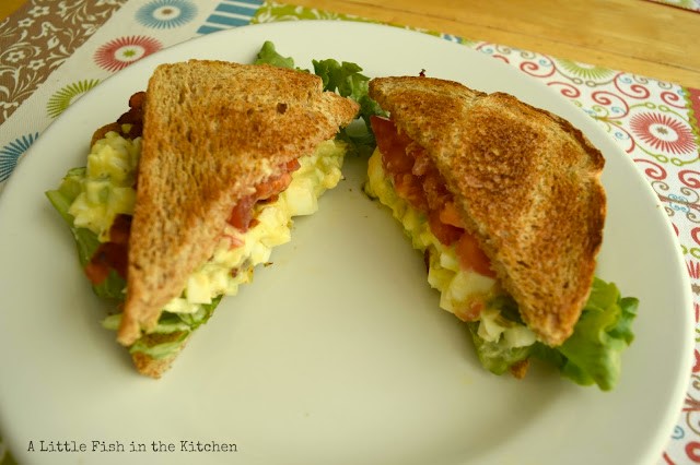 Toasted white bread is stuffed with creamy egg salad, bacon, tomato slices, and crisp lettuce. It's the ultimate brunch sandwich!
