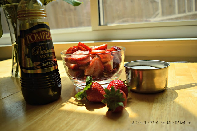 Ingredients for making strawberry balsamic jam have been gathered: sugar, fresh whole strawberries, and quality balsamic vinegar. 