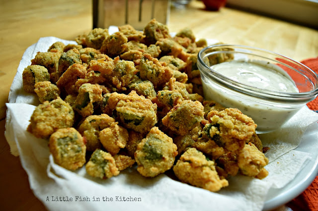 A freshly fried batch of okra is served with a measure of cream gravy or ranch dressing on the side. 
