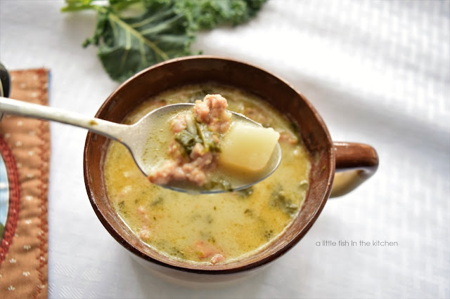 A spoonful of this rustic Tuscan white bean soup is ready to be savored. Hearty bits of kale, sausage, a tender potato are visible in this one tempting bite. 