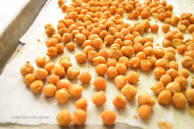 Golden, crisp freshly roasted chickpeas are cooking on a baking sheet. They are ready to serve.