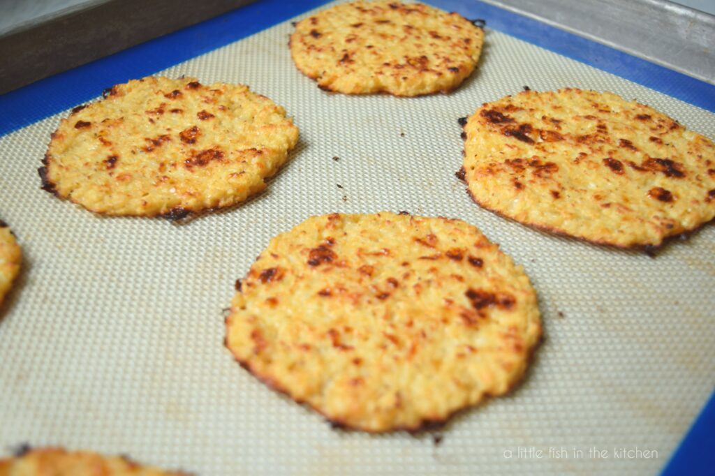 A picture of four cauliflower sandwich thins on a baking pan fresh out of the oven. 