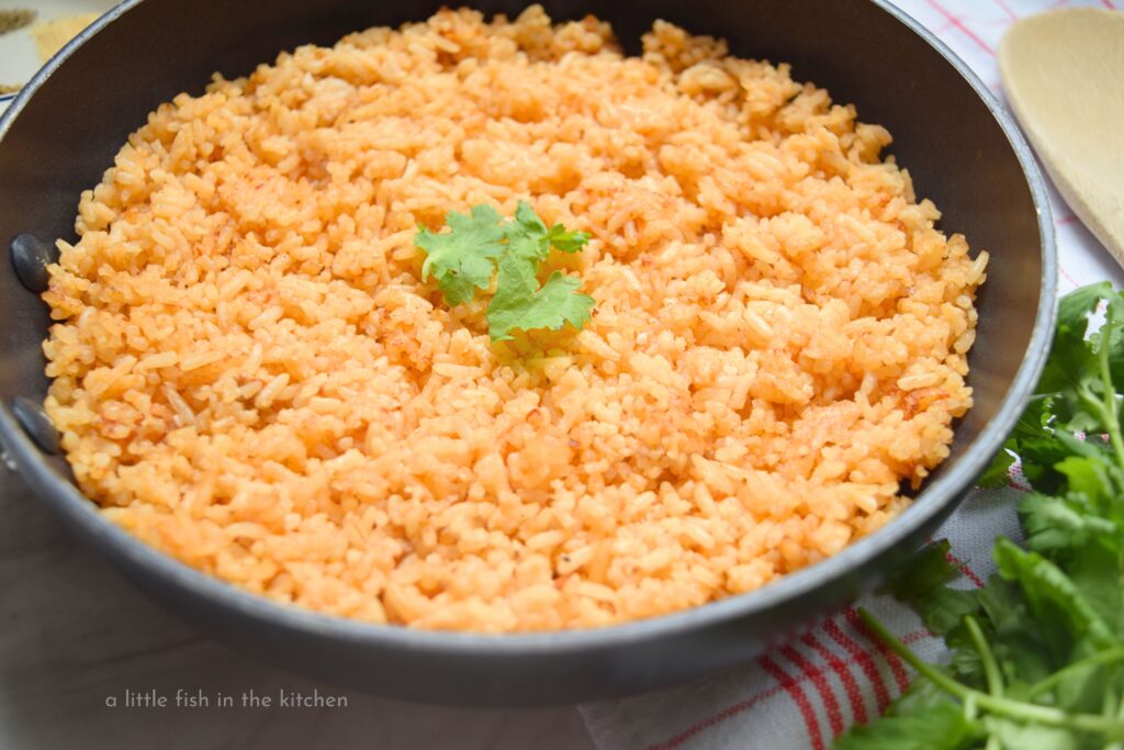 Skillet Mexican Red rice looks fluffy and delicious. The spices and tomato paste in the recipe give this flavorful rice an attractive light, red color.